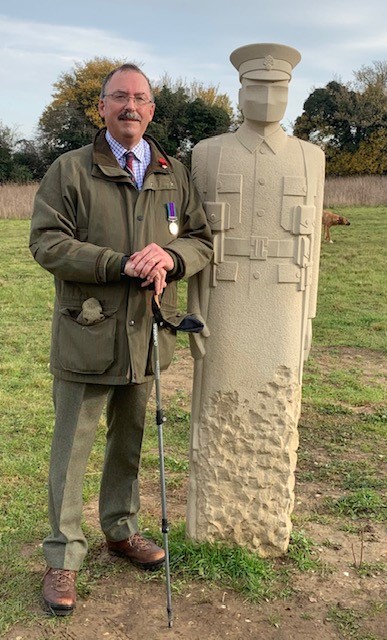 Man standing next to 'silent' World War 1 soldier sculpture